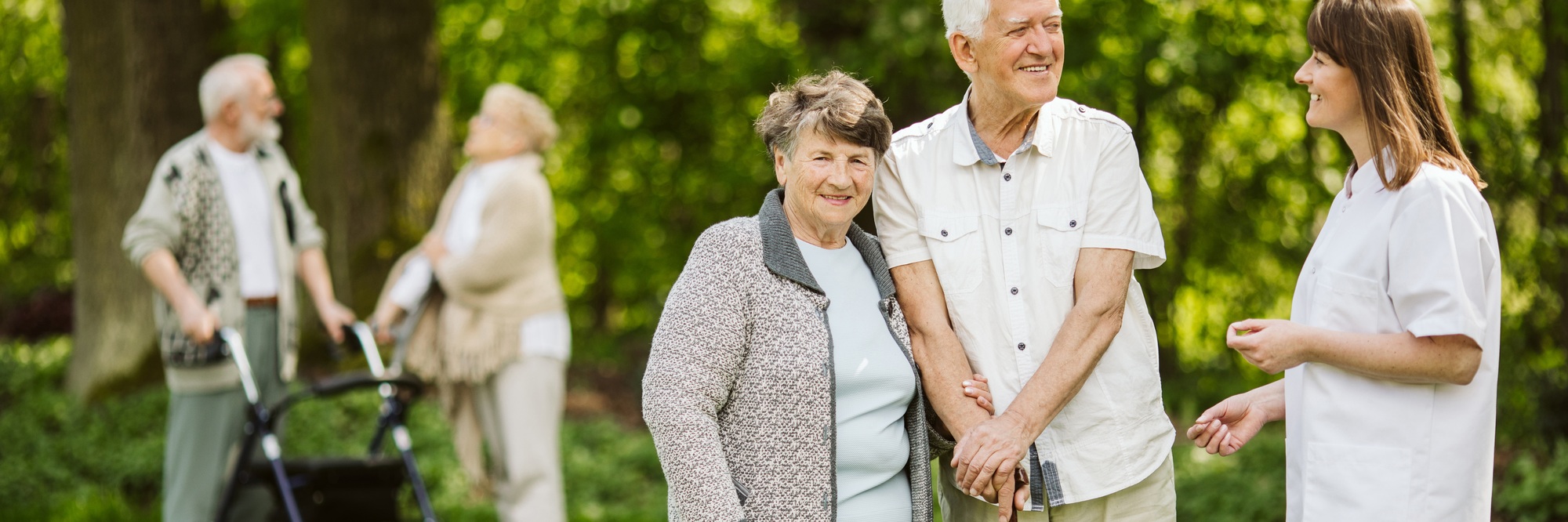 Elder people with the caregiver in the garden Elder people with the caregiver in the garden